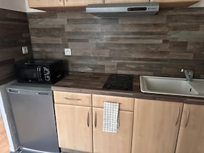 A compact kitchen with a microwave, stove, and sink. - BELLAIR1: Business or leisure stay right across from the train station (Saint Dizier)