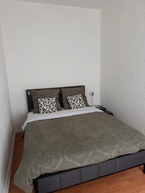 A single bed with a patterned bedspread and two pillows with a floral design. - BELLAIR1: Business or leisure stay right across from the train station (Saint Dizier)