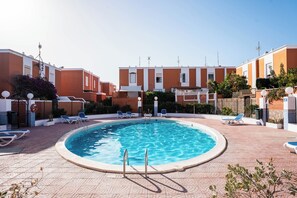 A swimming pool with lounge chairs and a clear sky. - Alisio Apartment in La Tejita (La Tejita)