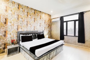 A modern bedroom with a marble headboard, a large bed, and a patterned wall. - Collection O Ayodhya Near Airport (Faizabad)