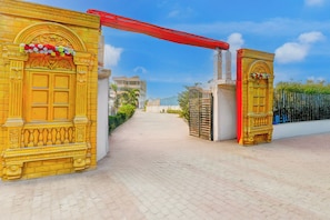 A gated entrance with ornate golden doors and a red overhead structure. - Collection O Ayodhya Near Airport (Faizabad)