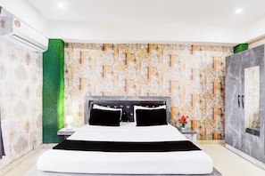 A modern bedroom with a large bed, a nightstand, a lamp, and a green wall. - Collection O Ayodhya Near Airport (Ayodhya)