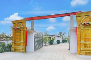 A gated entrance with ornate golden doors and a red canopy. - Collection O Ayodhya Near Airport (Faizabad)