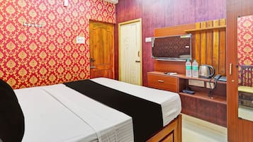 Una habitación de hotel con una cama, un escritorio con ordenador, un espejo y un armario.