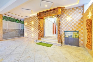 A reception area with a tiled wall, a wooden sculpture, and a fish tank.