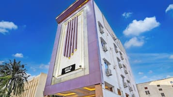 Un hotel con fachada moderna, un letrero llamativo y varios balcones.