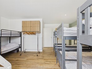 A dormitory room with bunk beds, a wooden wardrobe, and a radiator. - 15-person house, heated pool, near beach (Saint-Alban)