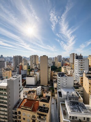 A cityscape with high-rise buildings, a clear sky, and the sun shining. - SETIN 2105 (São Paulo)