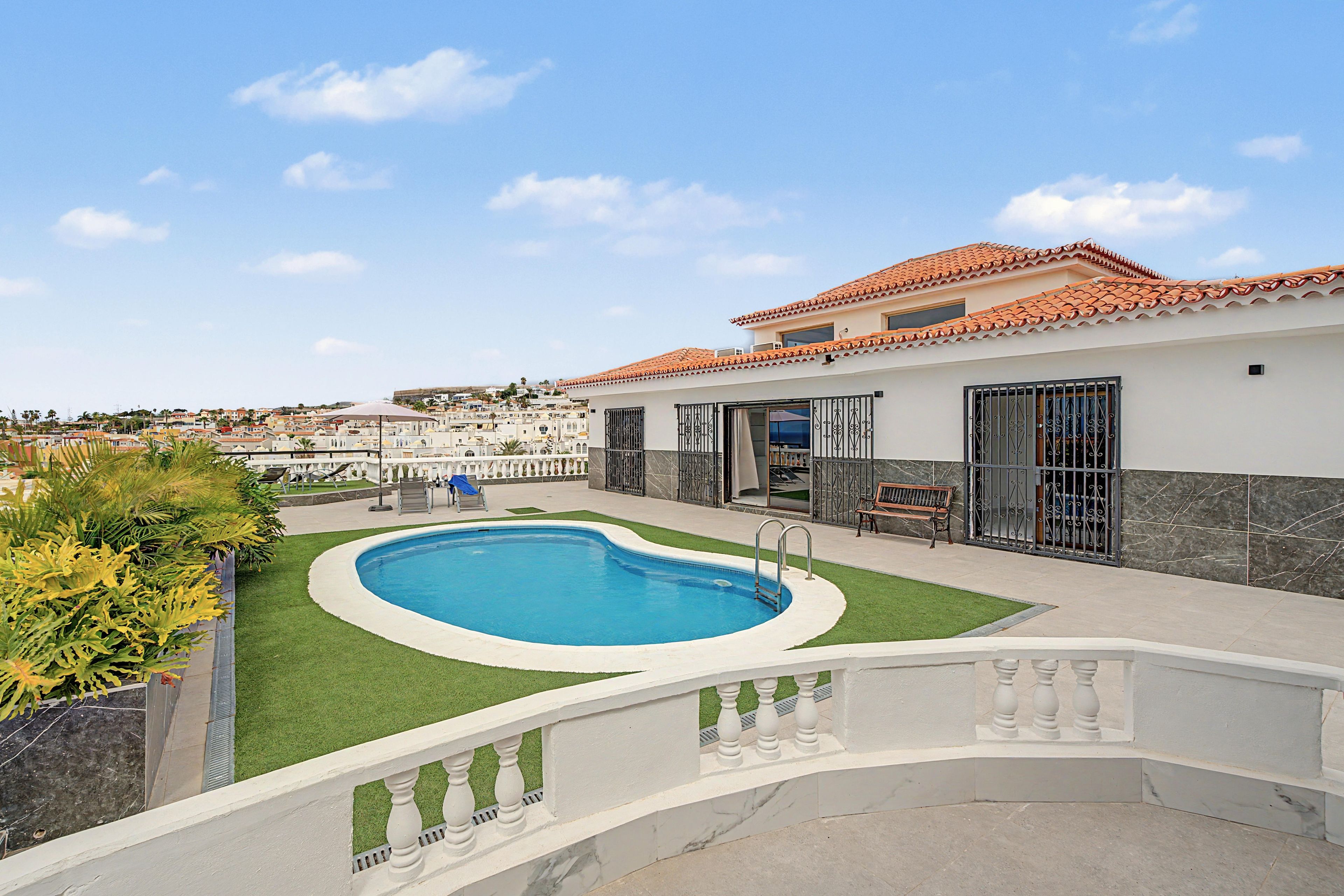 Una propiedad residencial con piscina, terraza cubierta y vistas a zona residencial.