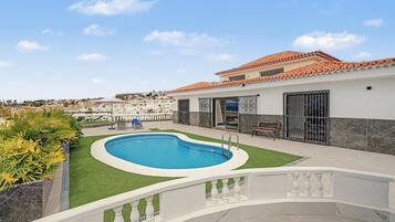 Una propiedad residencial con piscina, terraza cubierta y vistas a zona residencial.
