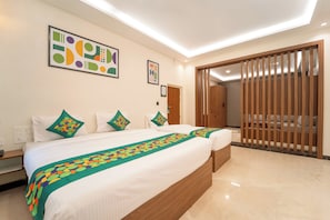 Une chambre d’hôtel avec un grand lit, une armoire en bois et un luminaire au plafond.