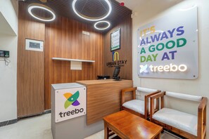 Een receptiebalie met een digitaal display, een bord met de tekst 'It's always a good day at treebo', en een logo aan de muur.