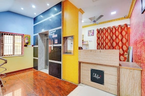 A reception area with a reception desk, a fire extinguisher, and a sign indicating room numbers.