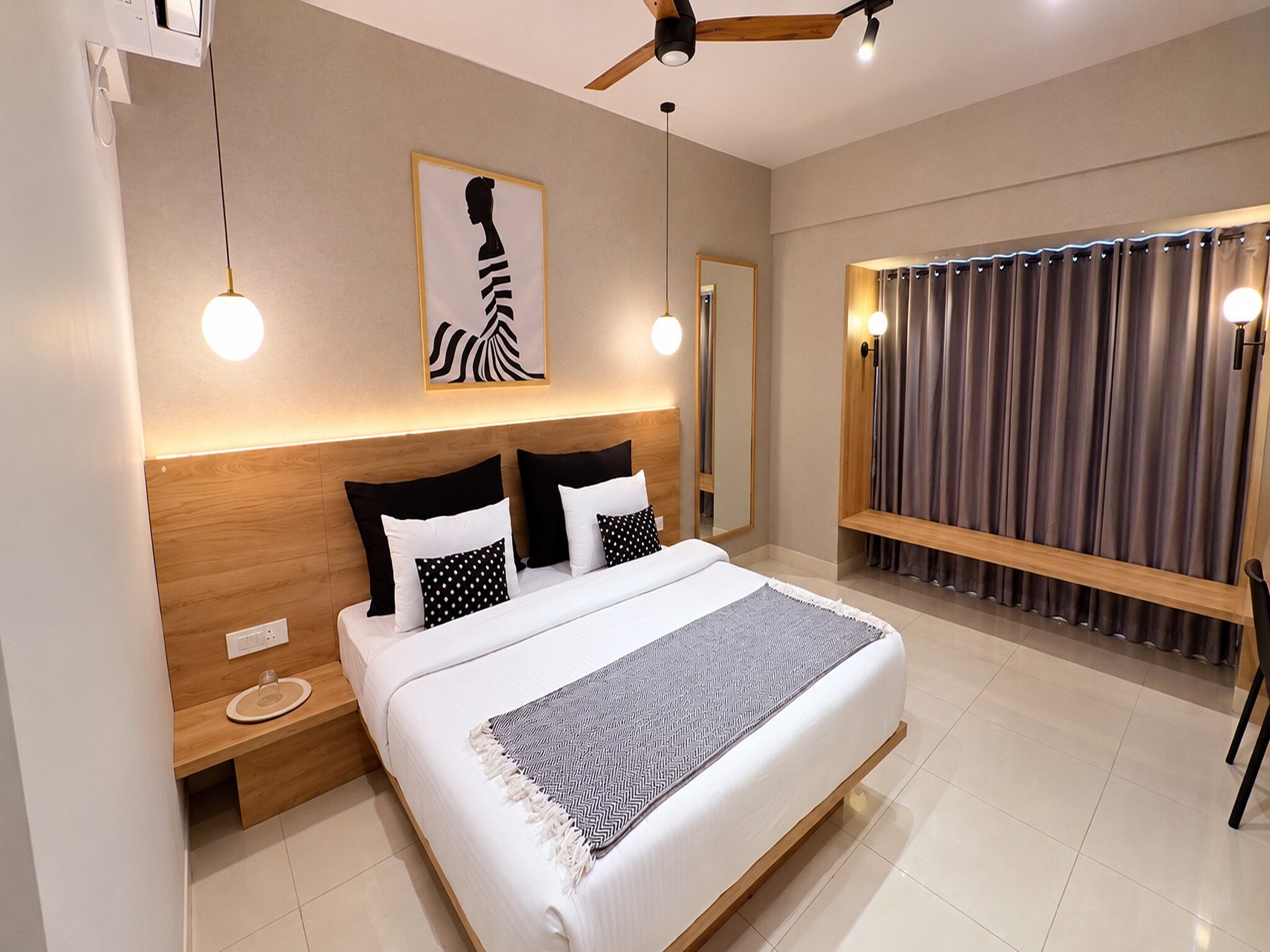 Una camera da letto moderna con un letto grande, comodini, una ventola a soffitto e vista sull'esterno.