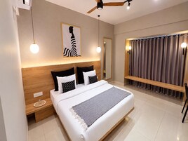 Una camera da letto moderna con un letto grande, comodini, una ventola a soffitto e vista sull'esterno.