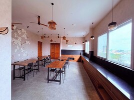 Un restaurante moderno con techos altos, vigas de madera a la vista y una barra larga con asientos.