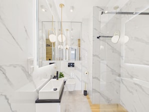Ein modernes Badezimmer mit einem großen Spiegel, einer Badewanne, einer Toilette und einer Duschkabine.