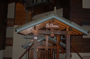 A wooden staircase with a sign reading 'Le Chamoi' and a number '813' on a metal plate.