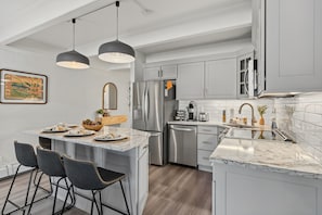 A modern kitchen with a central island, stainless steel appliances, and pendant lighting. - Luxury Lake View Dillon Condo Near Breckenridge Keystone Copper and ABasin (Dillon)