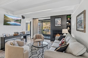 Ein modernes Wohnzimmer mit Kamin, rundem Couchtisch und Sofa.