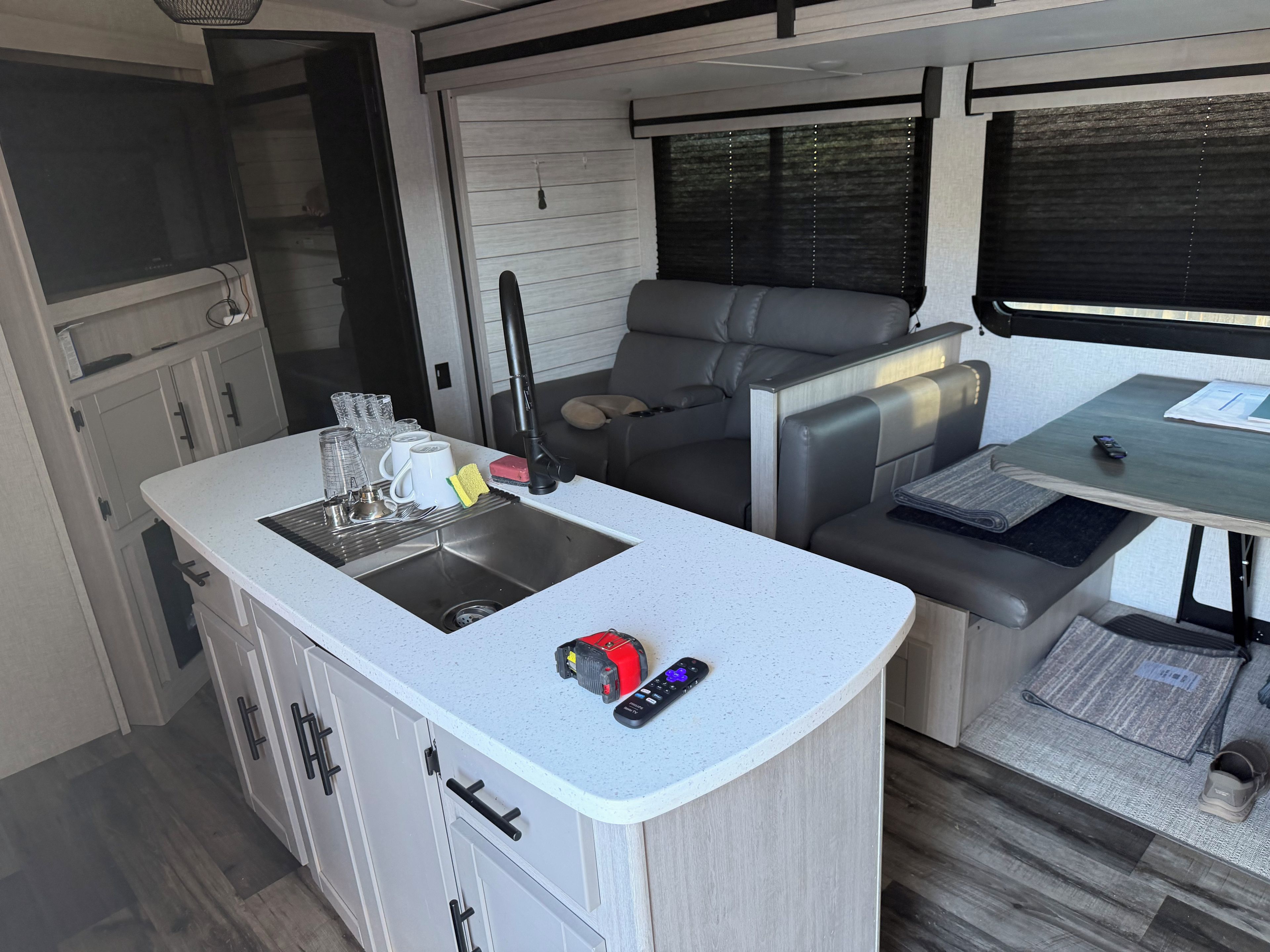 A compact kitchenette with a sink, a small dining area with a table and chairs, and a seating area with a sofa.