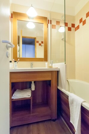 A bathroom with a wooden vanity, a mirror, a sink, a towel rack, and a bathtub. - Wifi, 10m from ski slopes, sauna, hammam, ski locker, 35-40m², Val Thorens (Val Thorens)