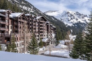 A multi-story hotel with balconies, set against a snowy mountain backdrop. - Wifi, 5m from ski slopes, swimming pool, sauna, hammam, balcony, ski locker, 46-48m², Flaine (Flaine)