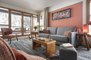 A modern living room with a grey sofa, wooden coffee table, and a chessboard. - Wifi, 5m from ski slopes, swimming pool, sauna, hammam, balcony, ski locker, 46-48m², Flaine (Flaine)