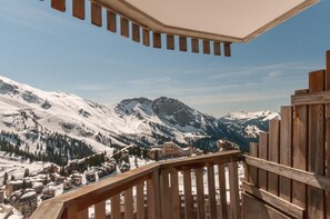 A wooden balcony overlooking a snowy mountain landscape with buildings and a clear sky. - 10m from ski slopes, balcony, ski locker, 21m², Avoriaz (Avoriaz)