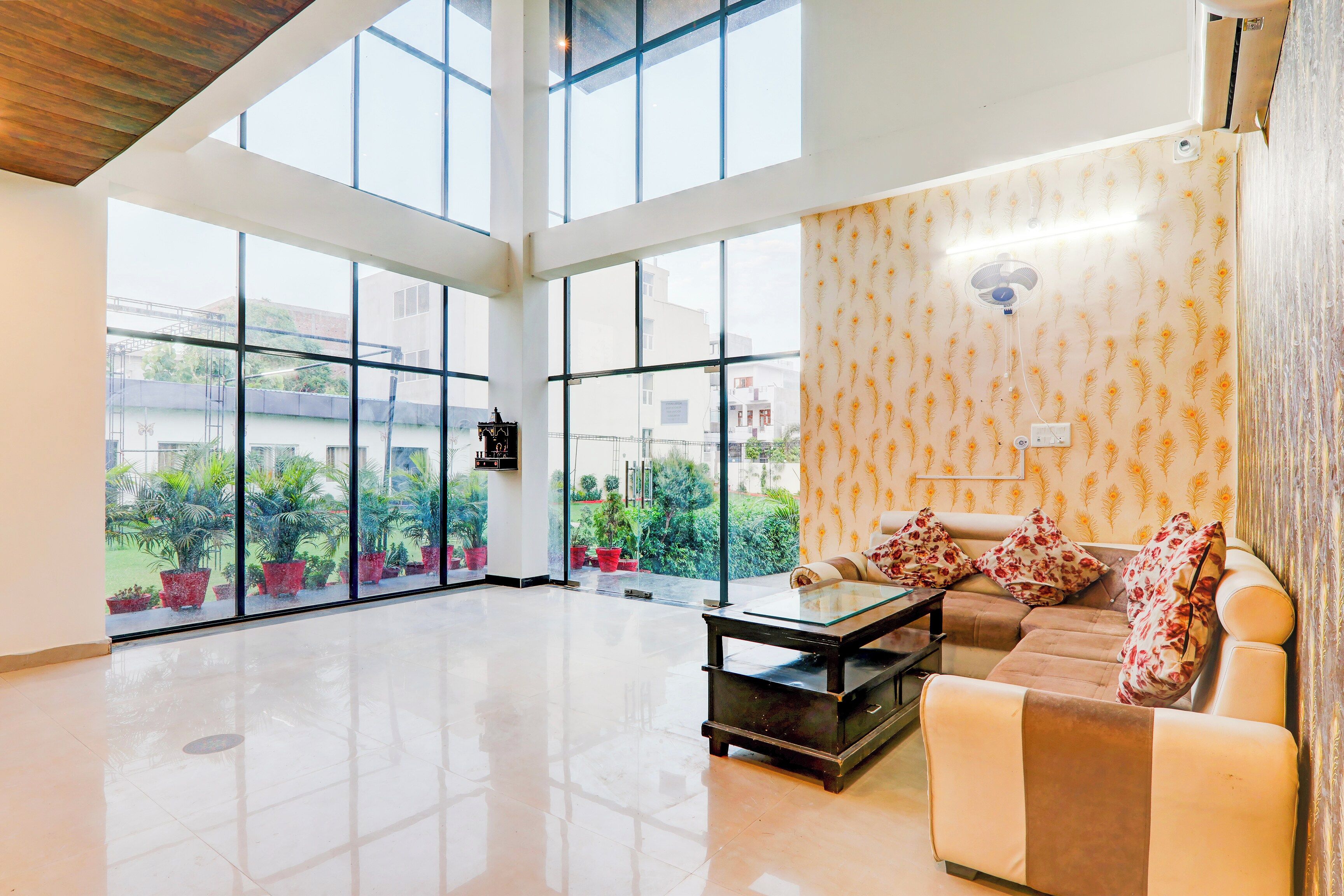 Amplia sala de estar con ventanas grandes, un sofá y una mesa de centro.