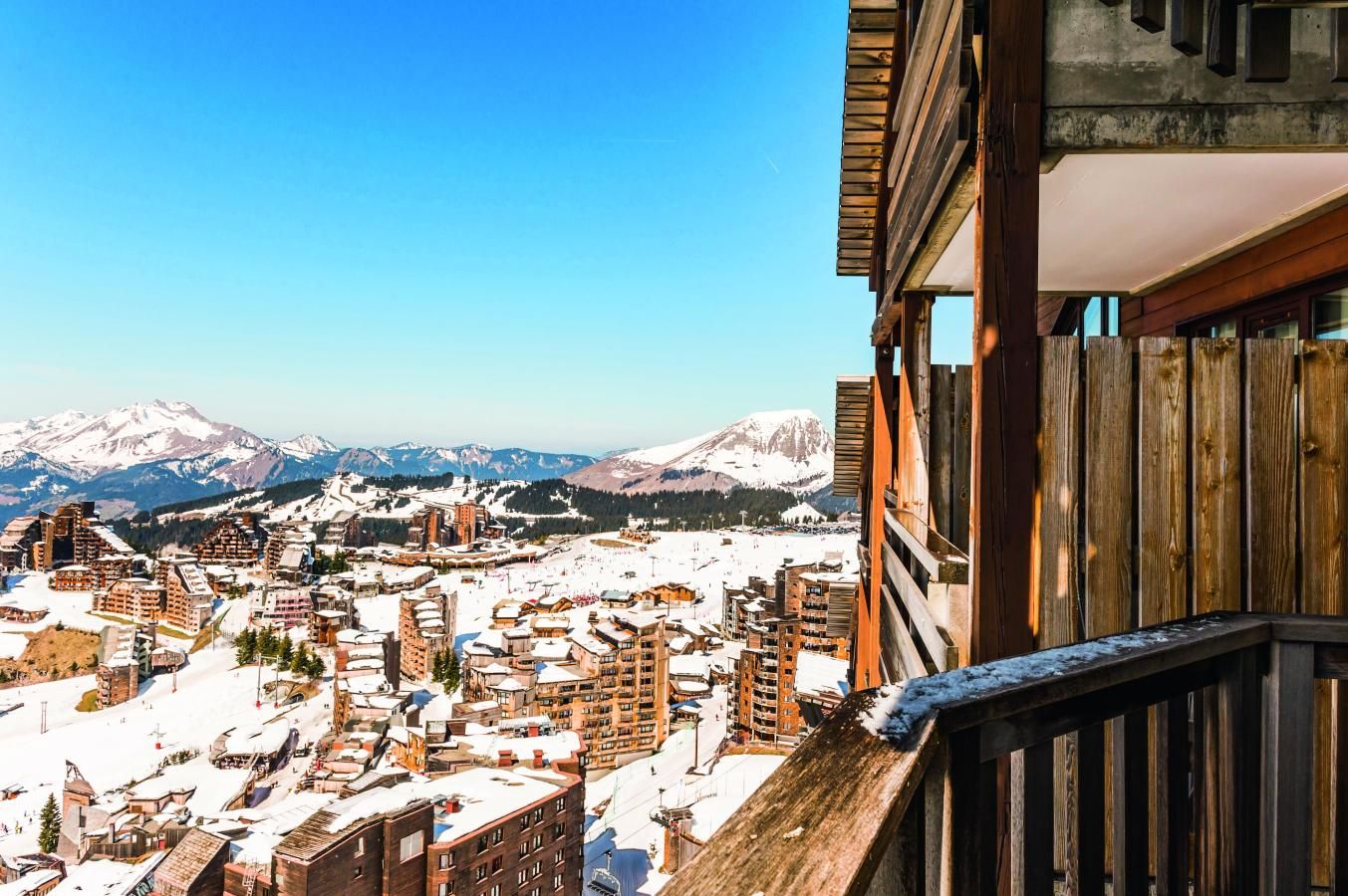 A snow-covered mountain town with buildings and a clear sky.