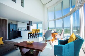 A modern living space with a kitchen, dining area, and seating arrangement. - Best Pool on beach and Rooftop. (Nuevo Vallarta)