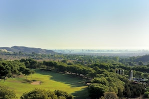 A golf course with a view of a city skyline in the distance. - Seraphim  | Luxury 3-Bed Penthouse at La Manga Club (Atamaria)