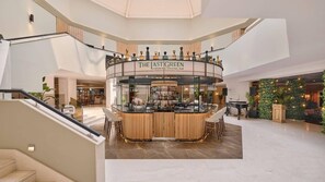 Eine moderne Bar mit einer gebogenen Theke, Barhocker und einer gut sichtbaren Getränkekarte.