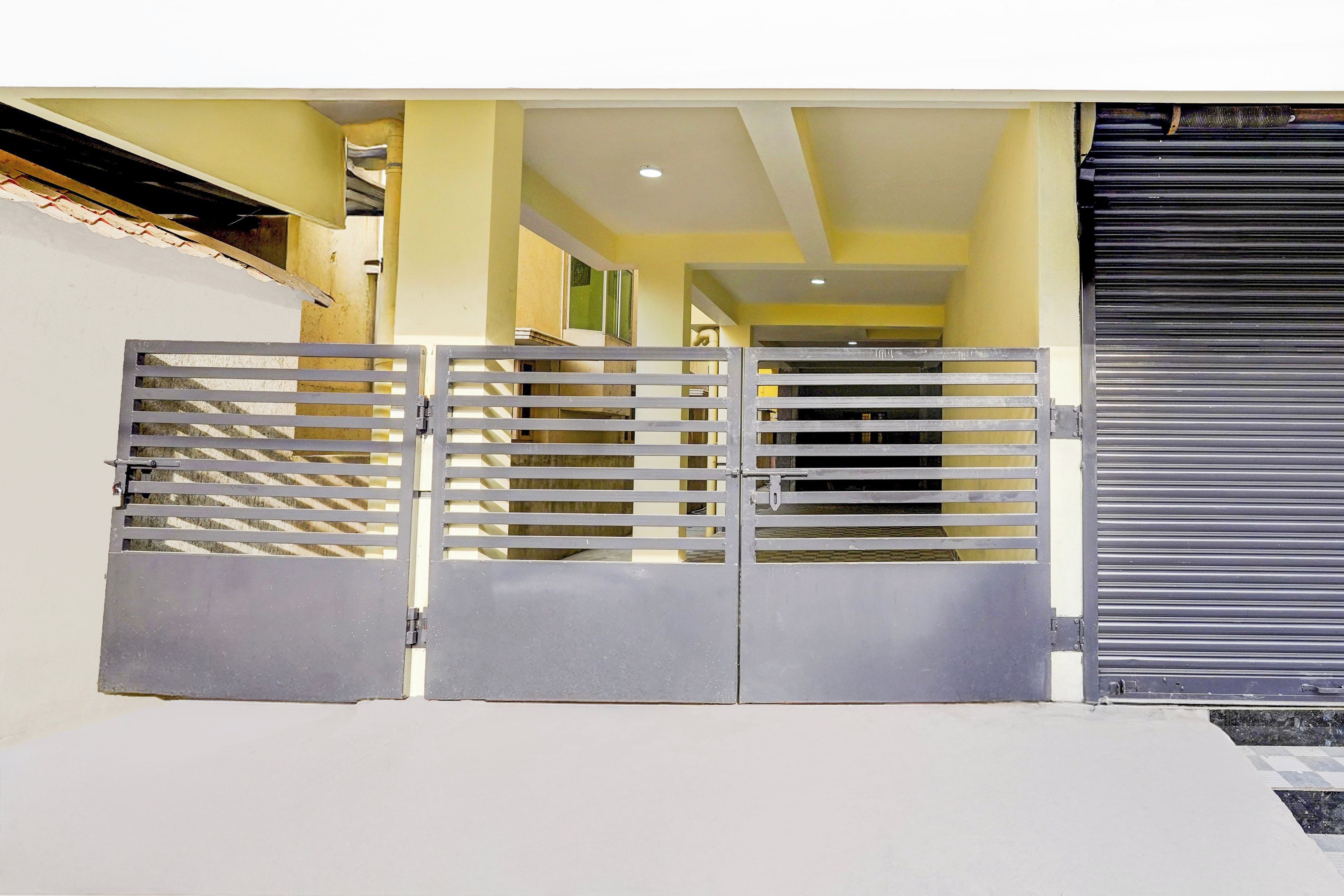 A gated entrance with a metal gate and a roller shutter door.