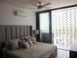 Um quarto com uma cama, ventoinha no teto, janela com vista e ar condicionado.