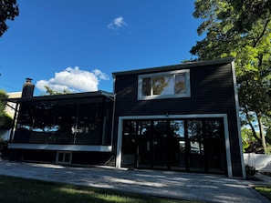 A modern two-story house with a large glass window and a chimney. - Beautiful 4-bedroom house with AC in pleasant Commack (Commack)