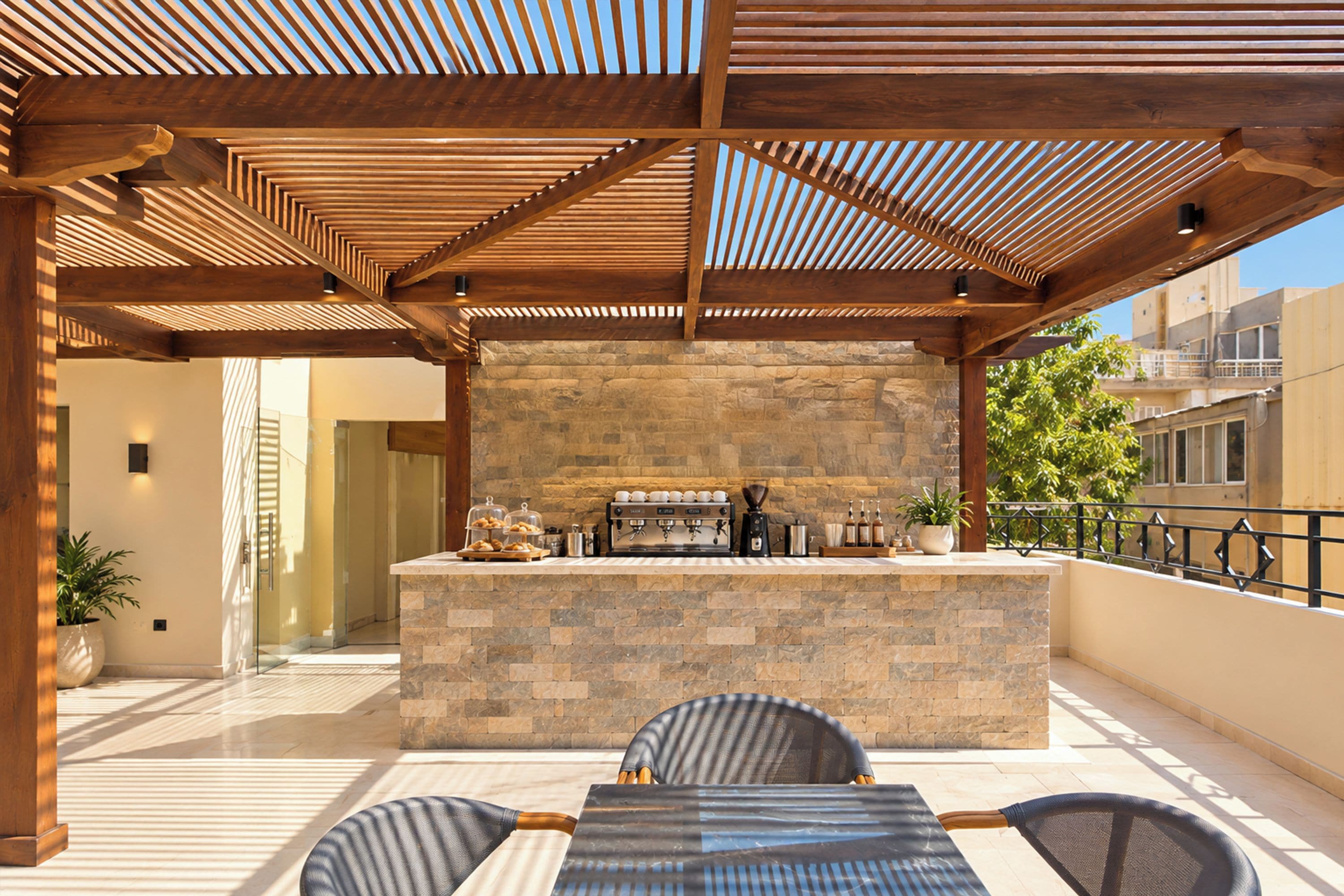 An outdoor patio with a stone bar, seating, and a view of the city.
