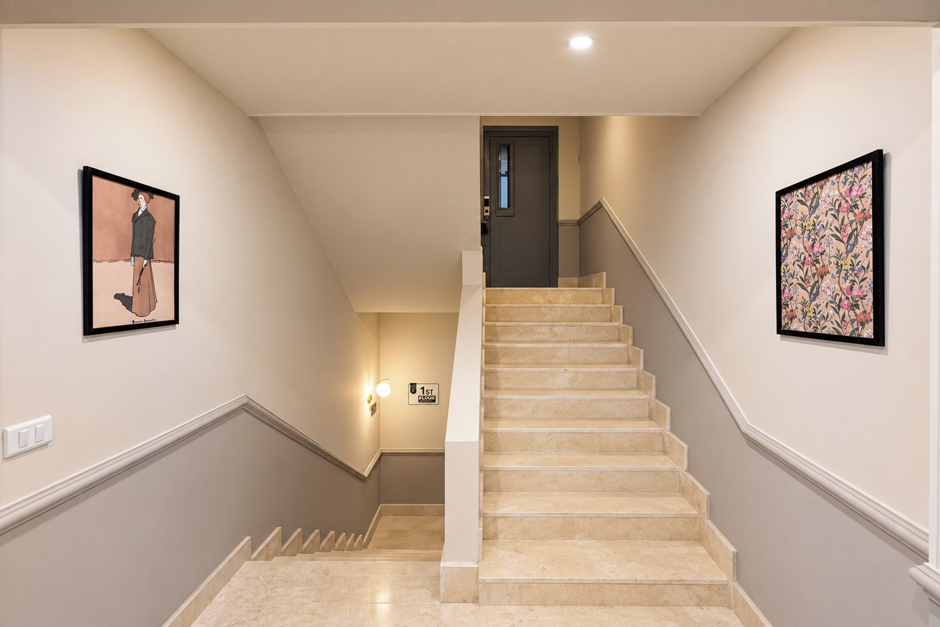 Una escalera con paredes color beige y una lámpara en la pared.