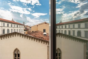 A view of a building with a tiled roof and arched windows, reflecting in a window frame. - Duomo 10 min · 2 separate bedrooms · Lift (FIRENZE)