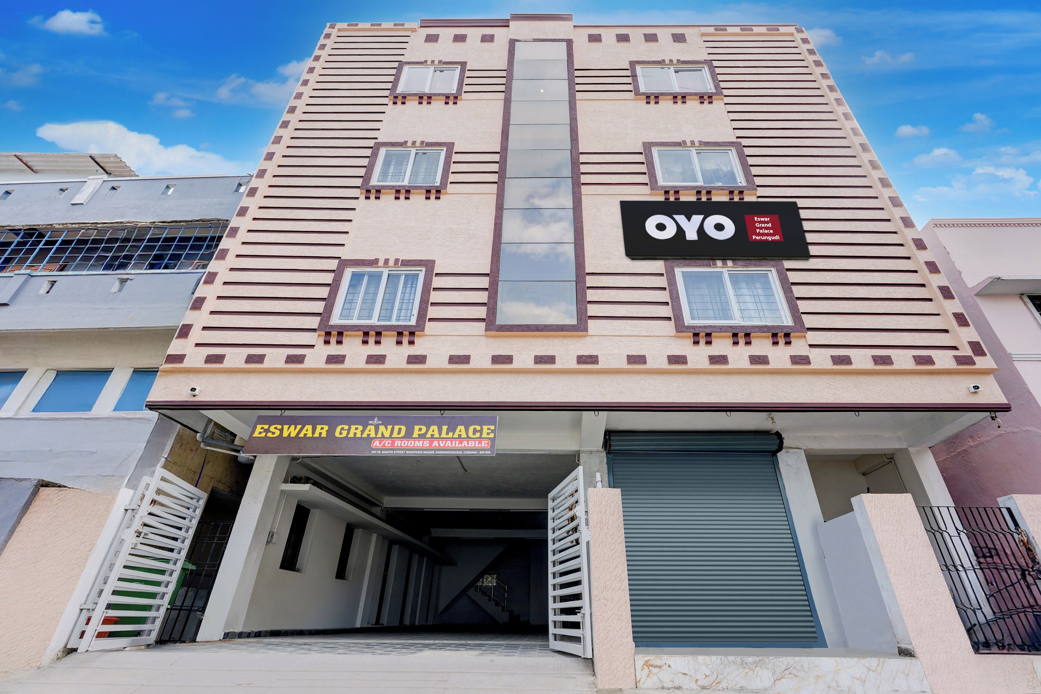 Un edificio con un letrero que indica 'ESWAR GRAND PALACE A/C ROOMS AVAILABLE'.