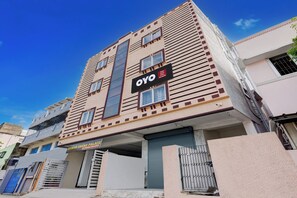 Un edificio de varios pisos con un letrero que indica 'OYO' y 'Eswar Grand Palace'.