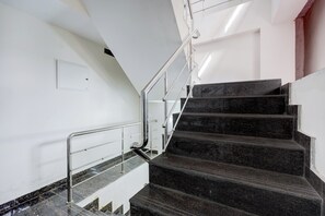 Una escalera con barandillas metálicas y peldaños de mármol.