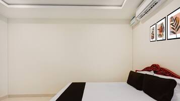 A bedroom with a bed, a ceiling fan, and wall-mounted air conditioning unit.