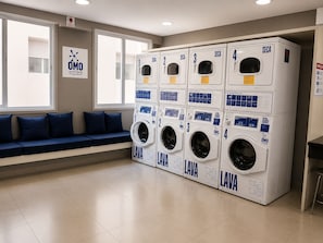 A laundry facility with four washing machines, each marked with a number and the logo 'SECA'. - Vibe 1604 (São Paulo)