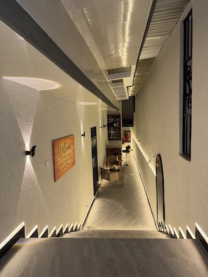 Et hotel med gange, trappe, velkommenskilt og barområde.