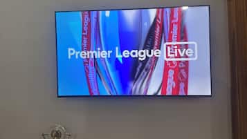 A television mounted on a wall displaying 'Premier League Live'.