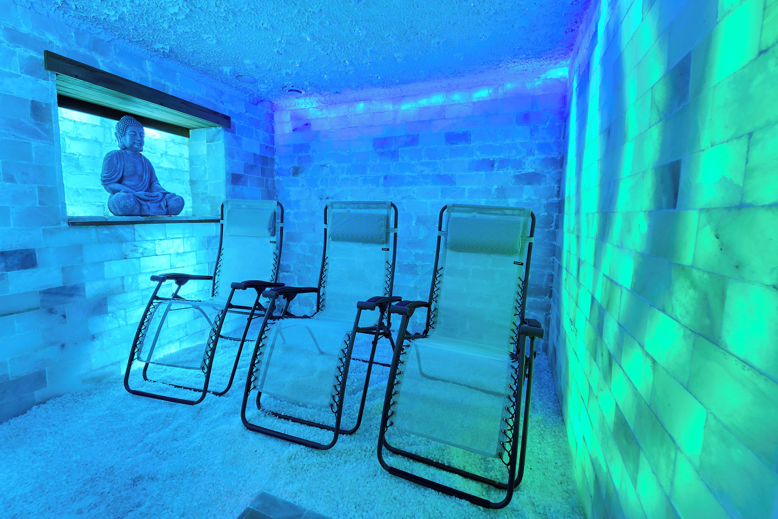 A room with four reclining chairs, a statue, and a window.