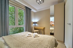 Un dormitorio con una cama grande, un escritorio y una silla.