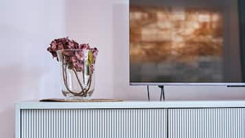A white, ribbed entertainment center with a flat-screen TV mounted above it.
